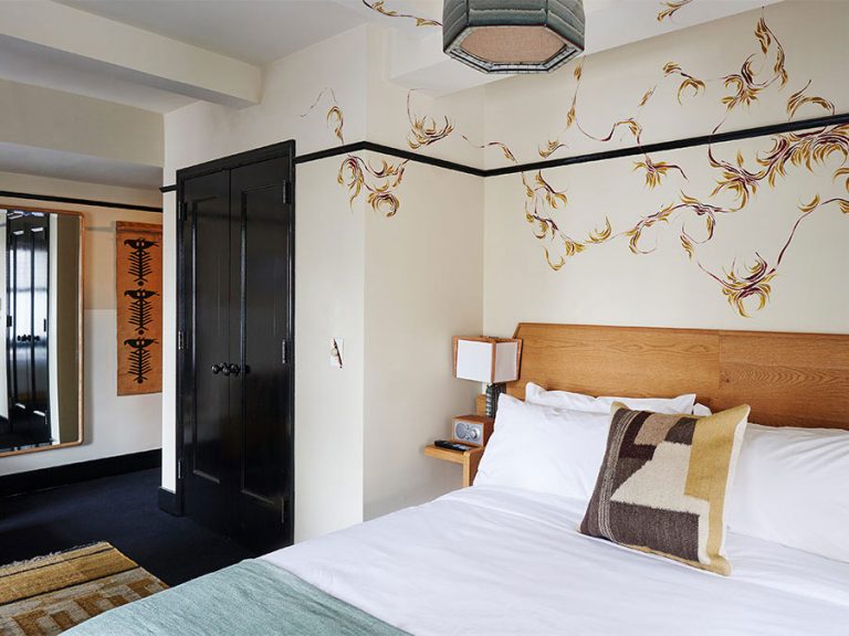 Bed and builtin wardrobe in a Freehand Hotel New York in a corner King room